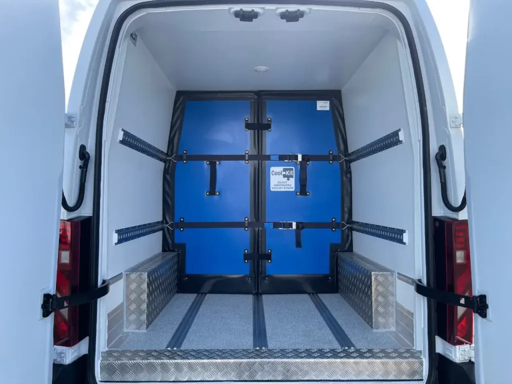 Interior of a CoolKit refrigerated van conversion featuring insulated multi-temperature compartments and secure load restraint system
